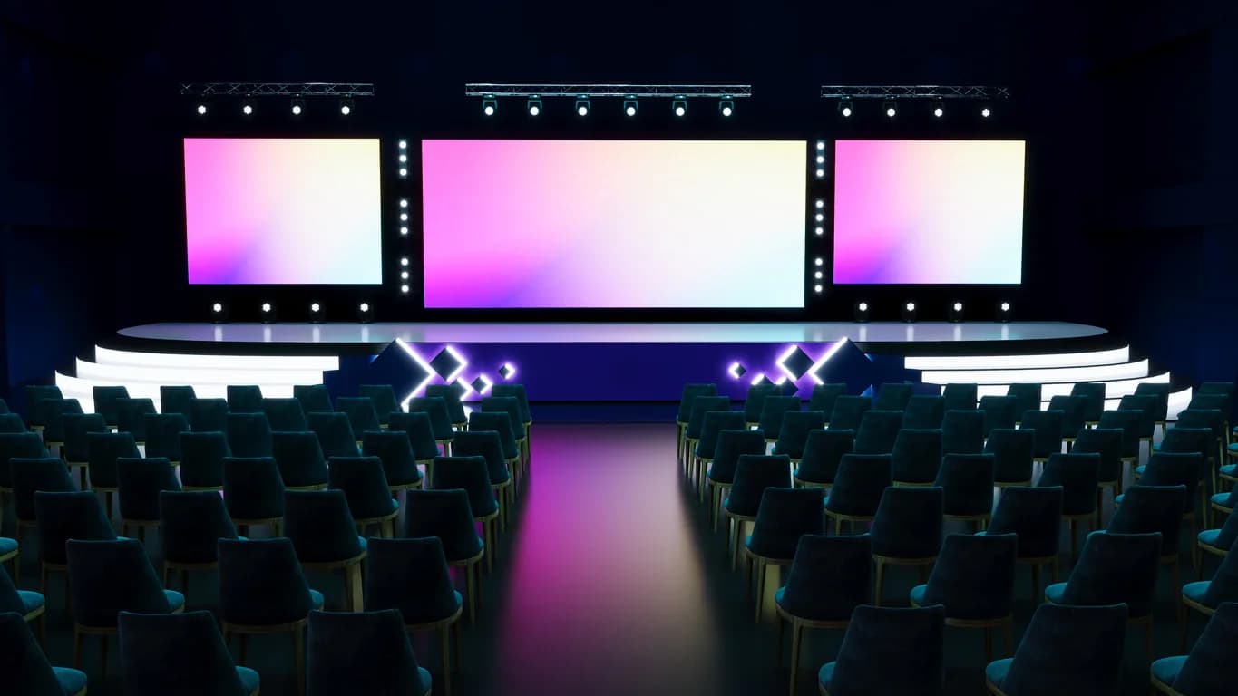 Corporate event stage with projection screens lighting audio equipment and presentation support