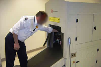 Airport Screener Reaching In Machine