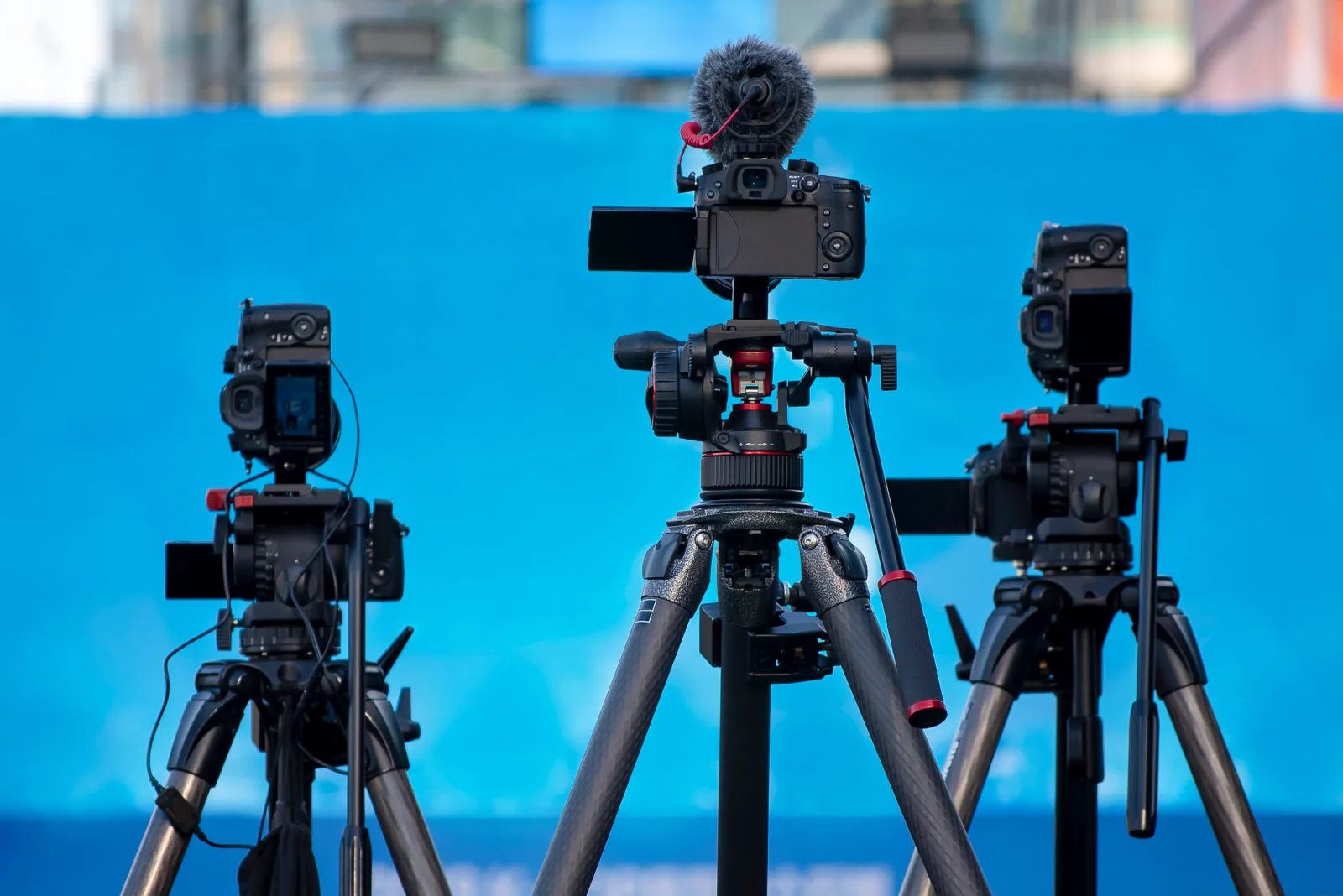 Professional camcorder on tripod recording a keynote speaker at a conference or training session