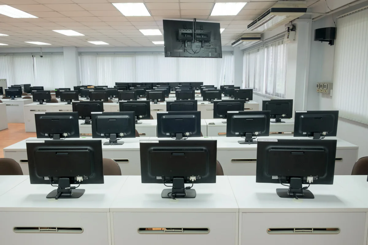 All in one computers lined up in a clean training room and reception workspace setup