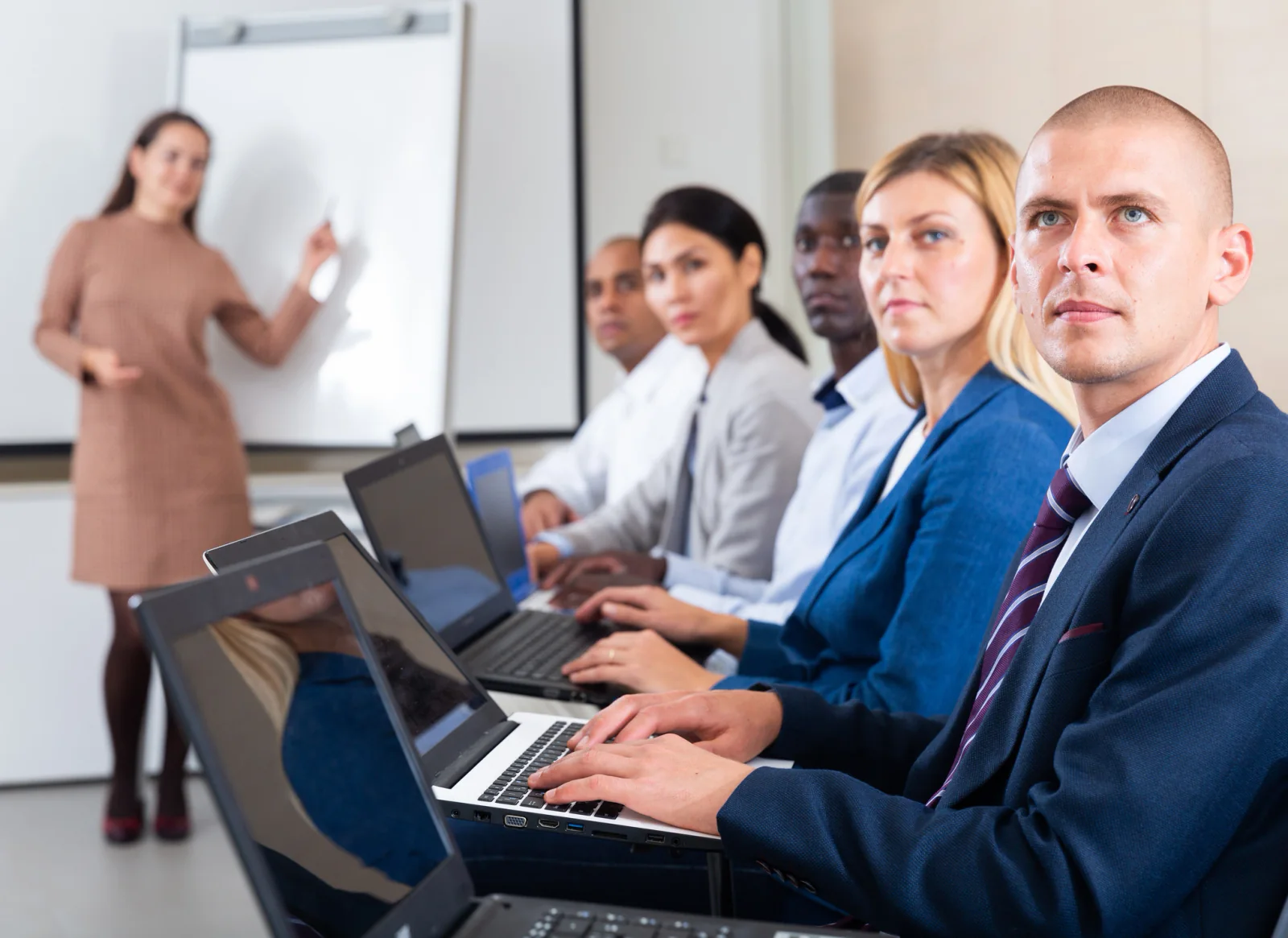 Instructor led classroom with rows of rental computers monitors and attendees in a temporary onsite training lab