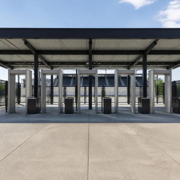 Stadium entrance gate with walk-through metal detector screening