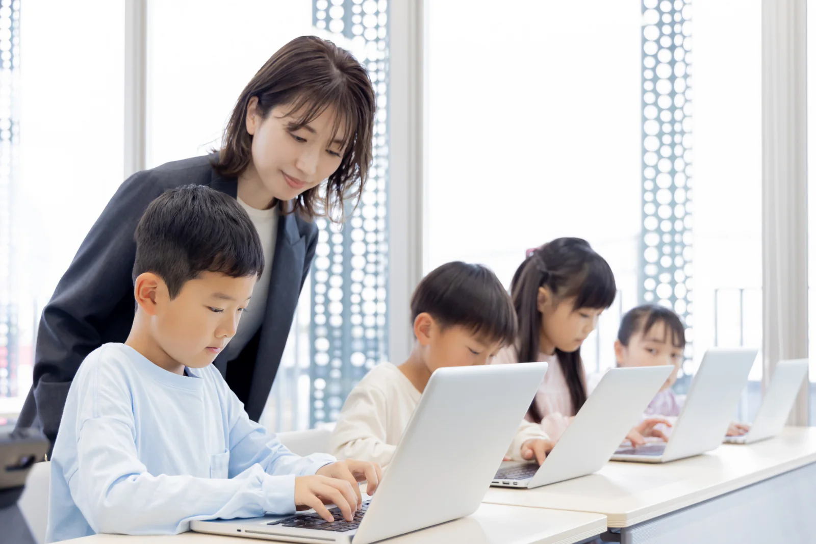 Adult learners using laptops in a community education classroom at an off-site training location