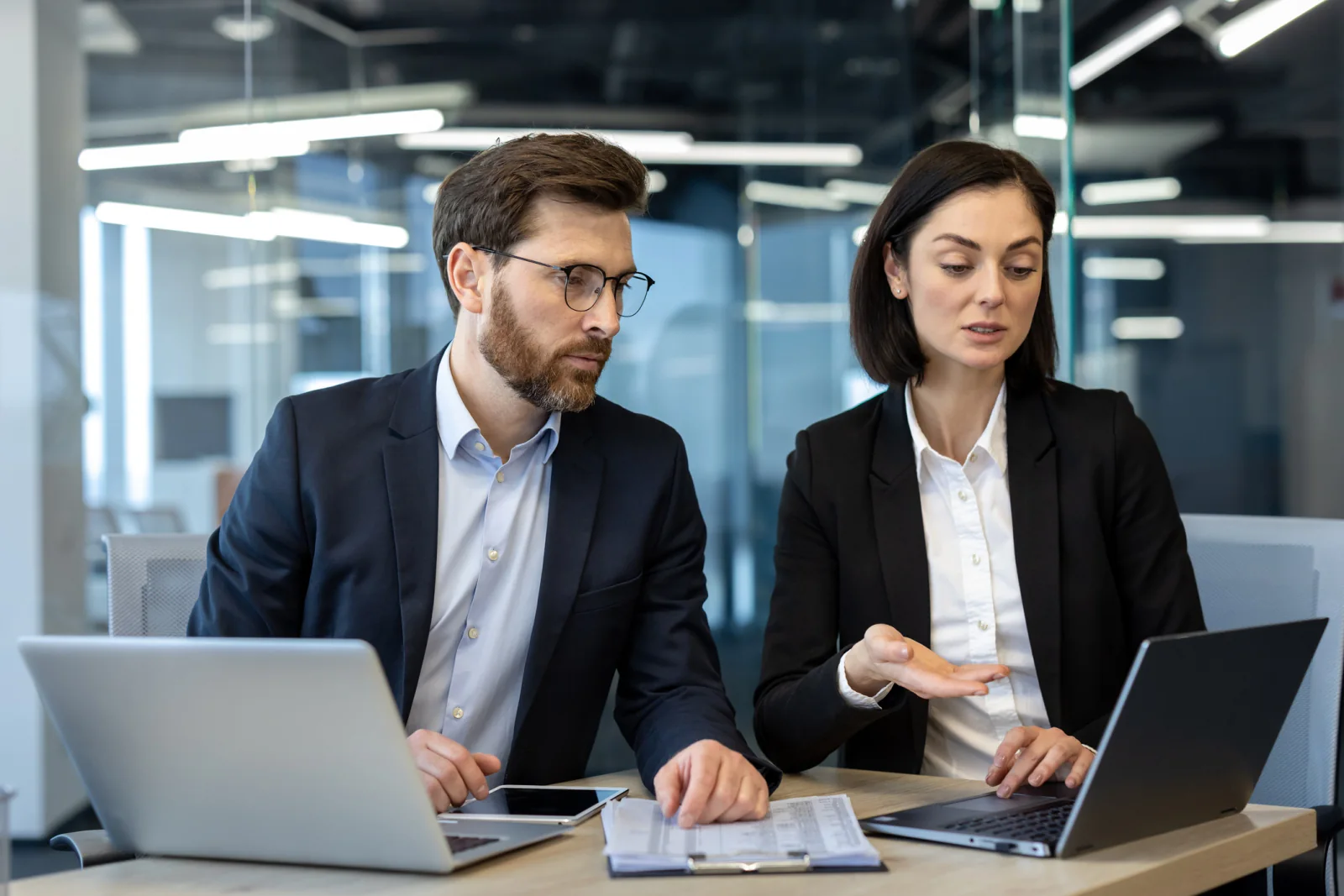 Audit professionals working in a temporary financial services war room with laptops, dual monitors, and printers during busy season