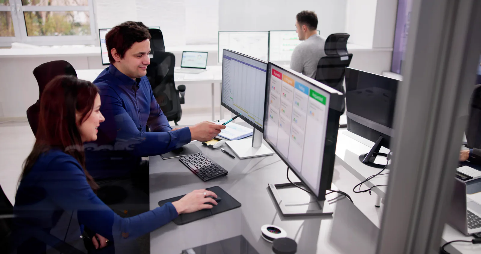 Attorneys and legal staff reviewing documents on multiple monitors in a financial services case room