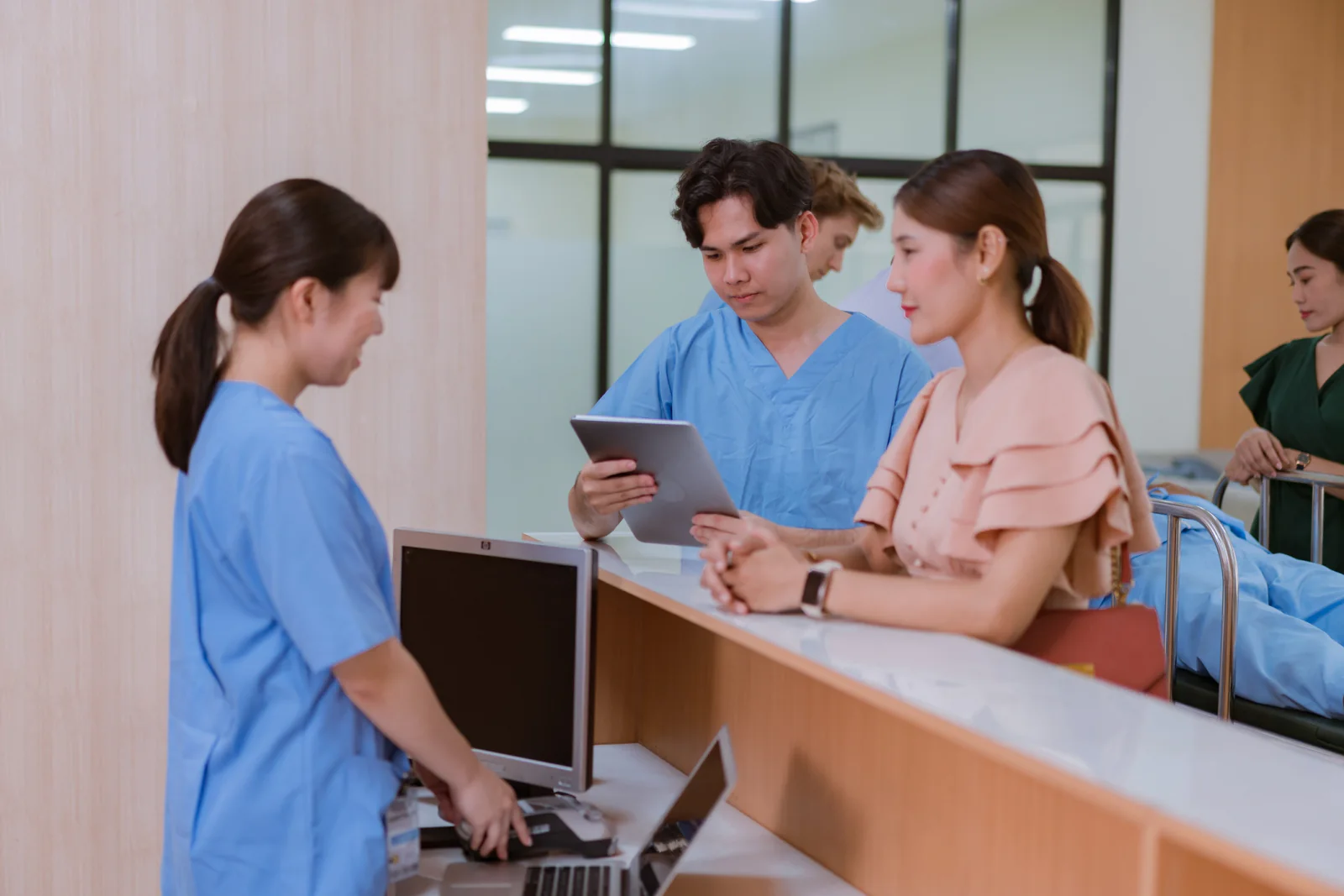 Healthcare workers using tablets and laptops at a vaccination clinic registration area