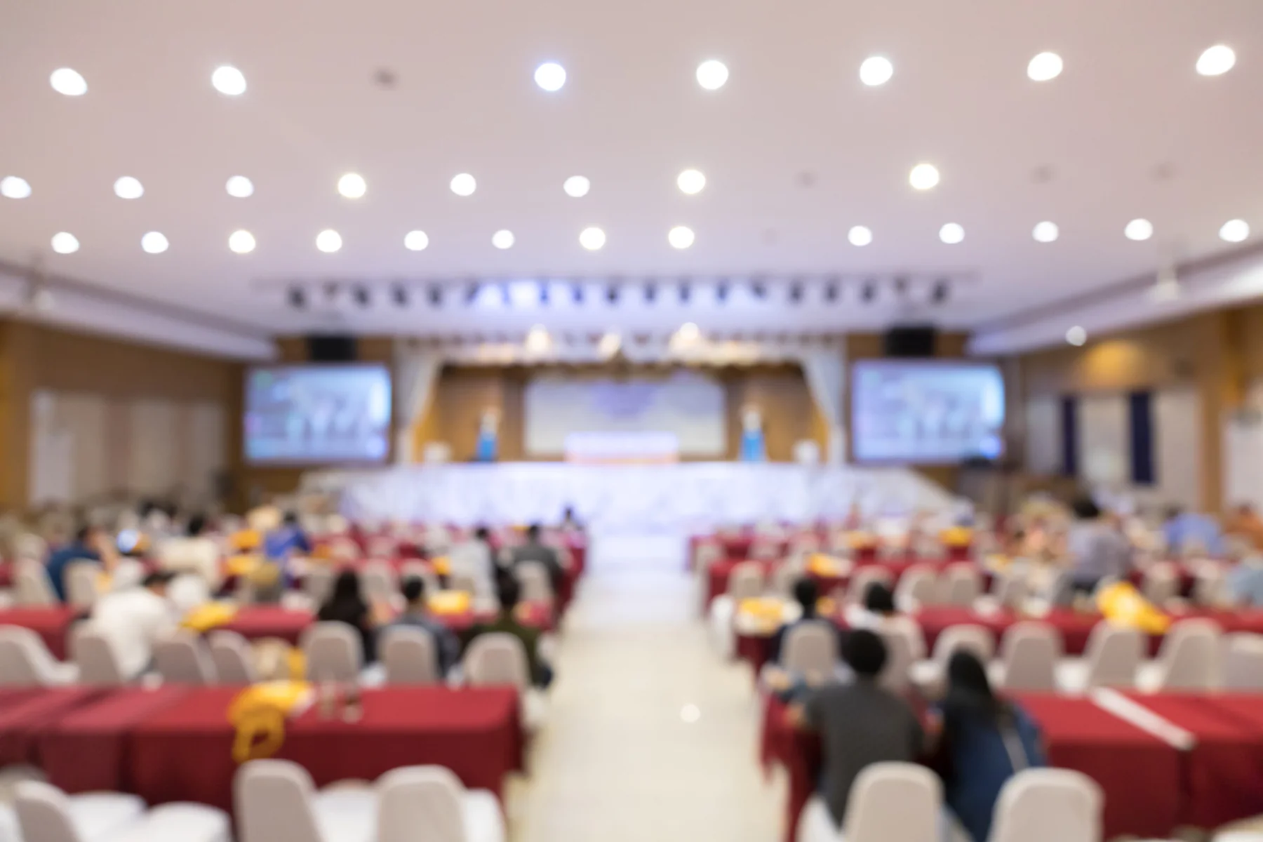 Meeting organizers coordinating multi-city events using laptops and displays