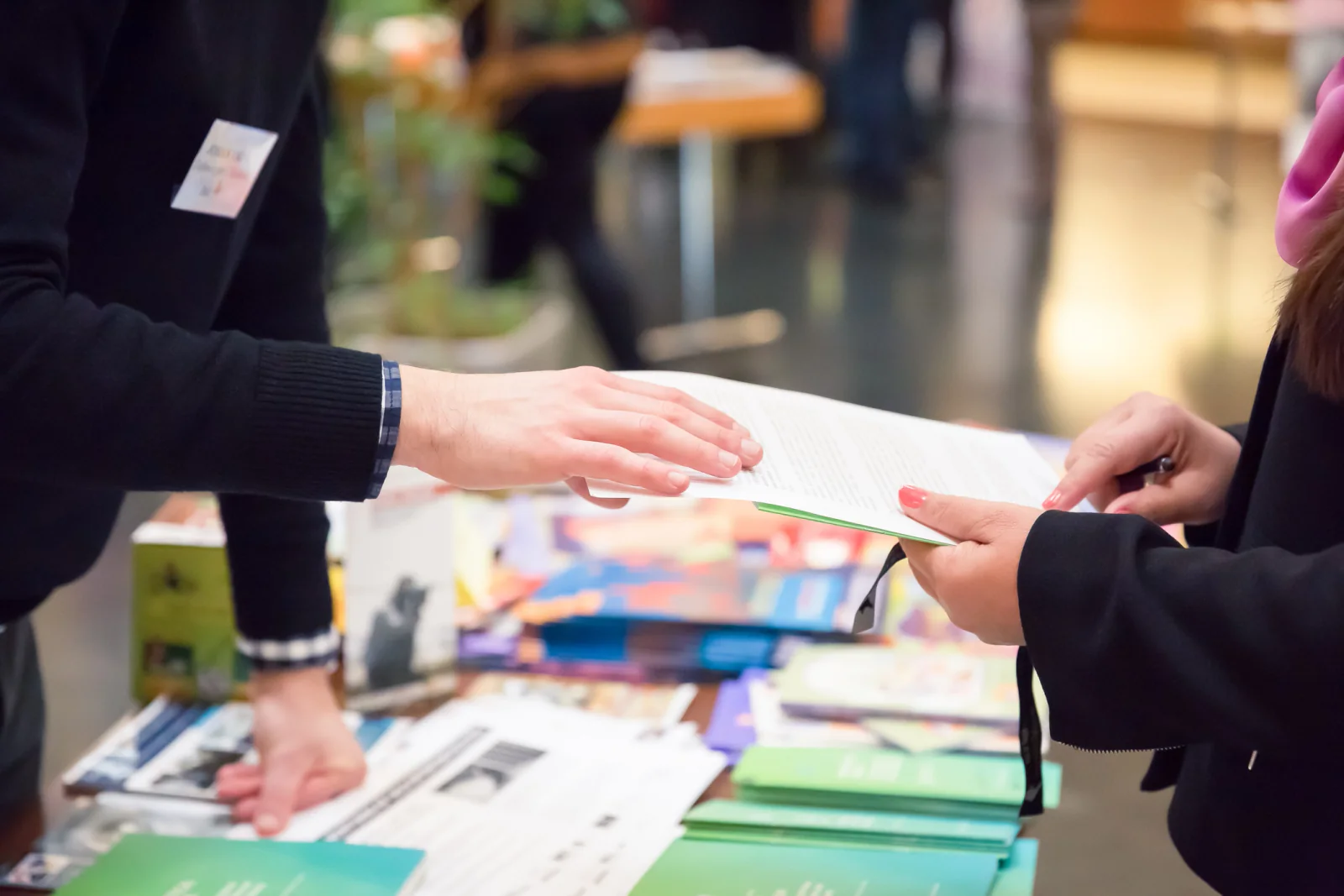 Legal conference registration and event setup with check-in tablets, badge printers, large displays, and attendees arriving