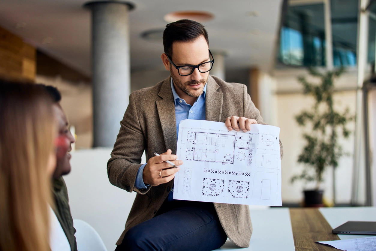 Event planner reviewing a conference floor plan for multilingual interpretation services