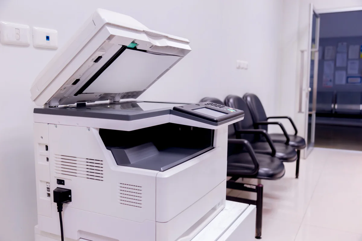 Conference or event admin copier setup with printed documents and temporary office support equipment