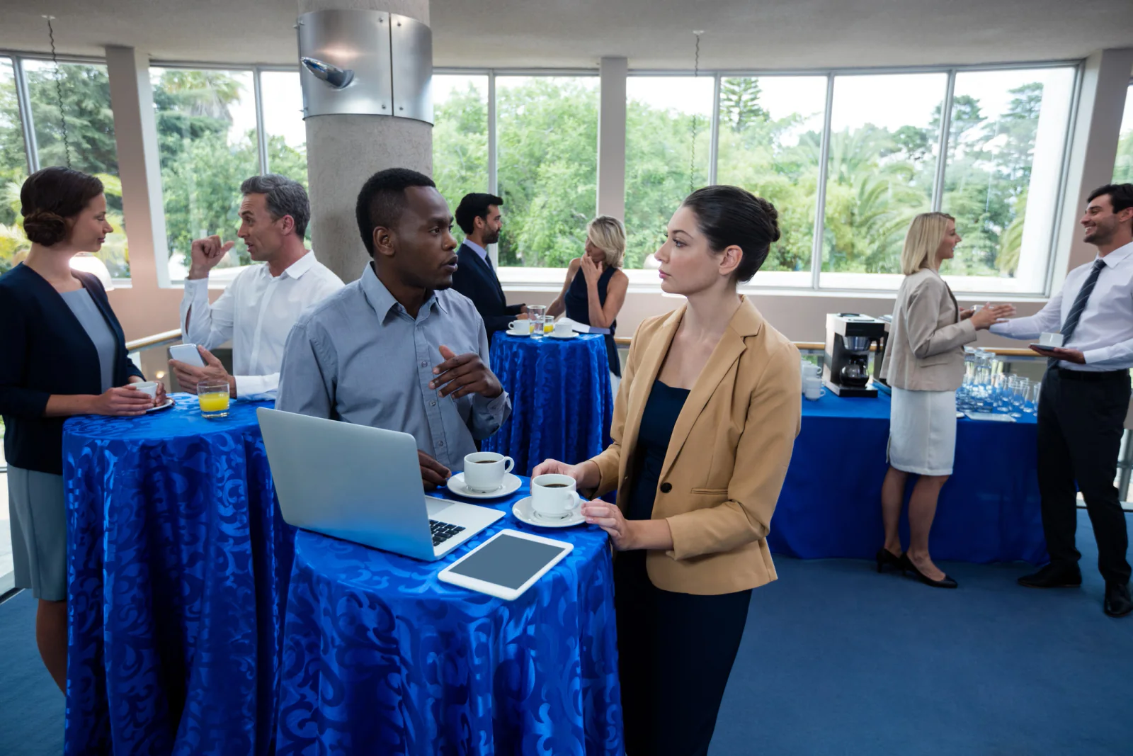 High-throughput event registration entrance with multiple rental check-in stations, tablets, and staff processing large attendee volume