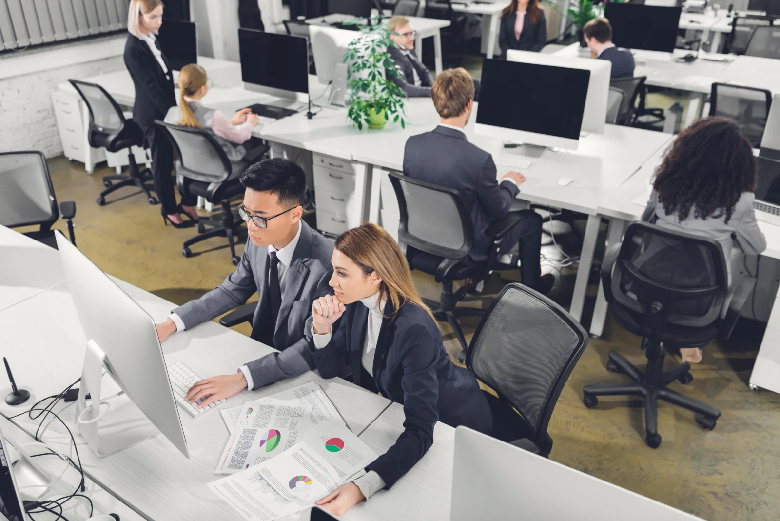 Overflow staffing office with rows of rental laptops, monitors, keyboards, and accessories for temporary employees