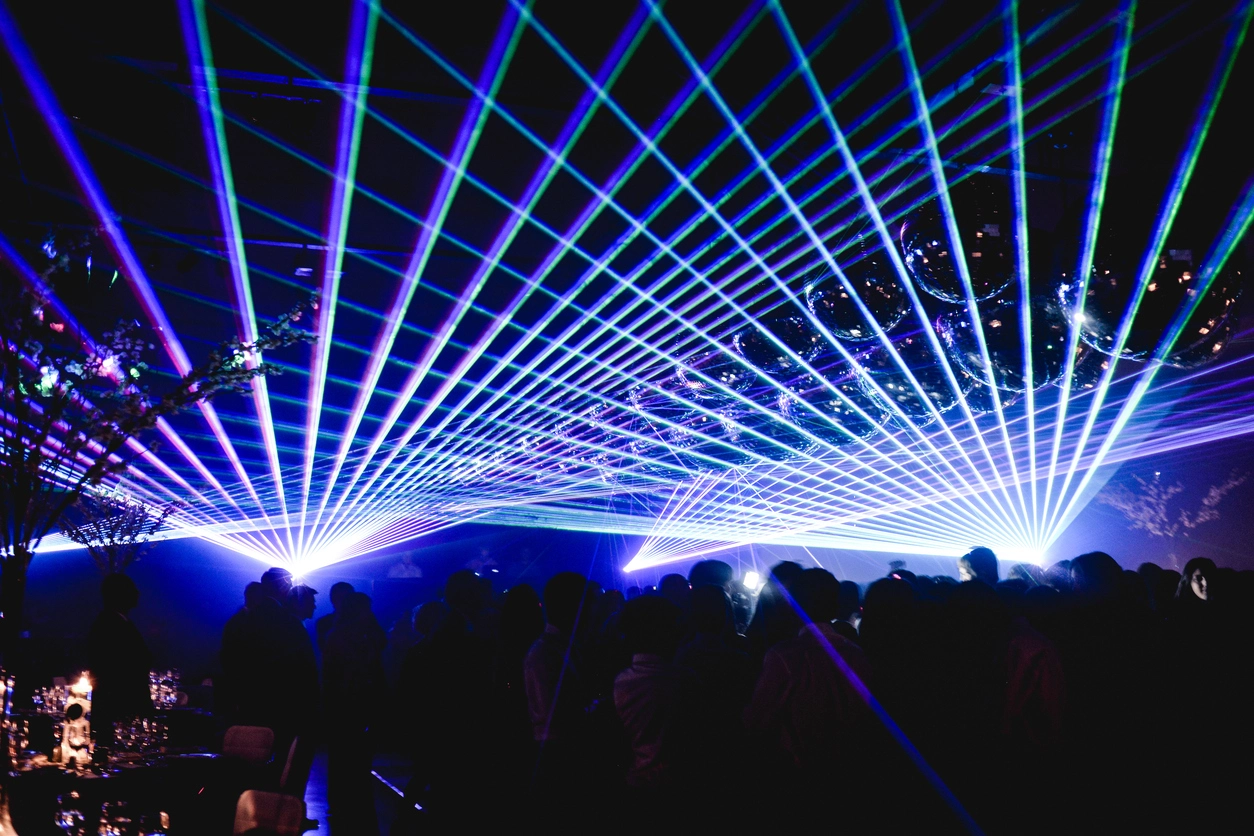 Professional laser effects creating colorful beams above a live event stage and audience