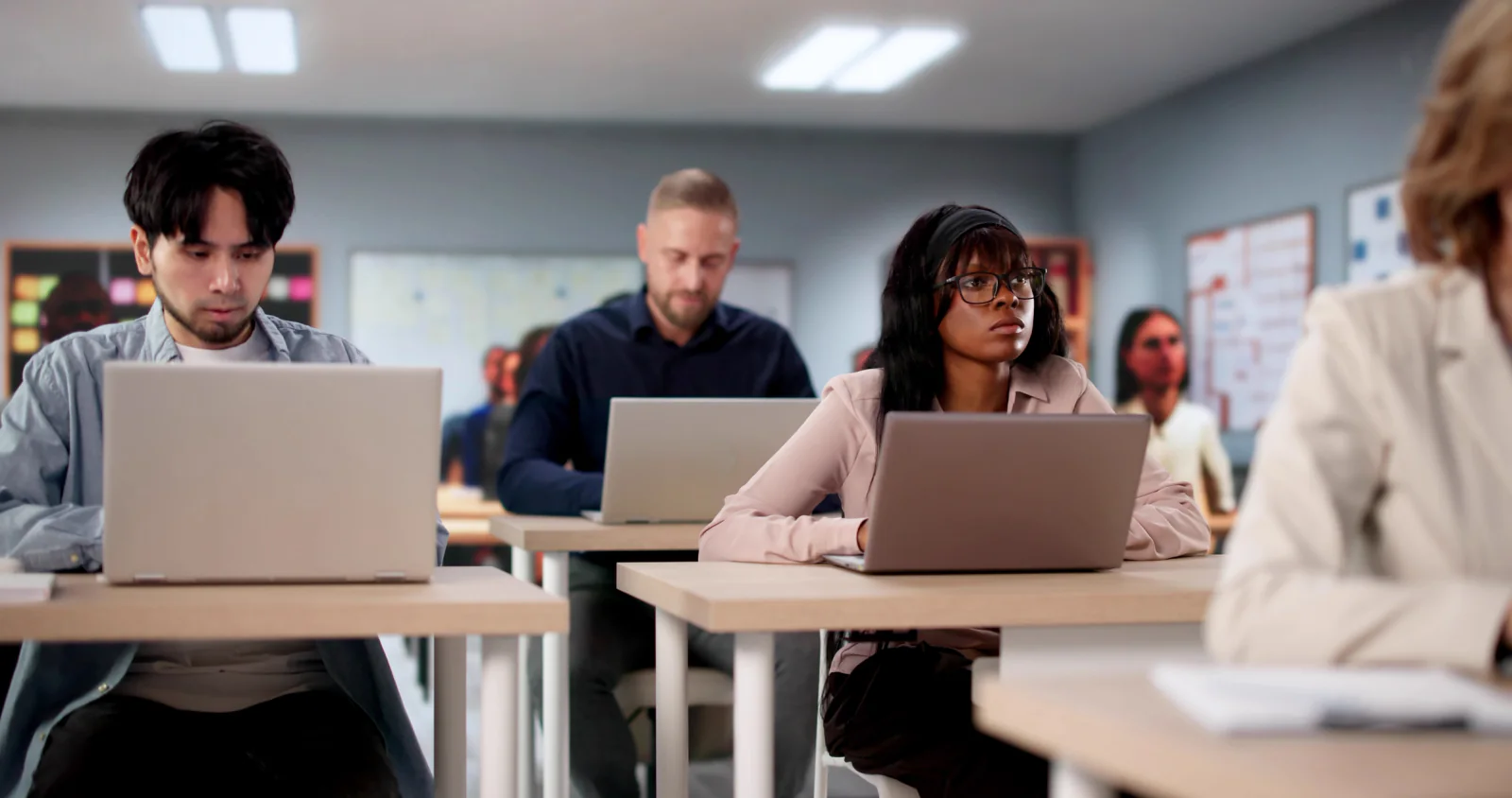 Corporate training classroom with standardized rental laptops and learners participating in an employee onboarding session
