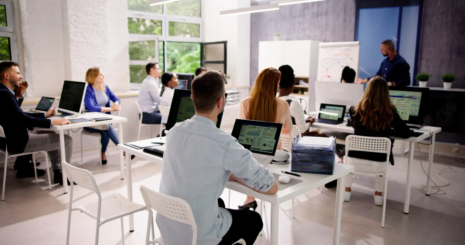 Spare classroom laptops, chargers, and training accessories prepared for quick replacement during a live learning session