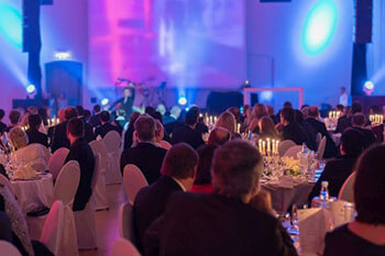 Attendees sitting around circular tables at a banquet