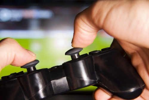 A close up view of a pair of hands on a gaming controller