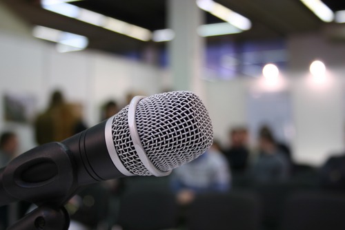 A microphone ready to be used in front of a small gathering