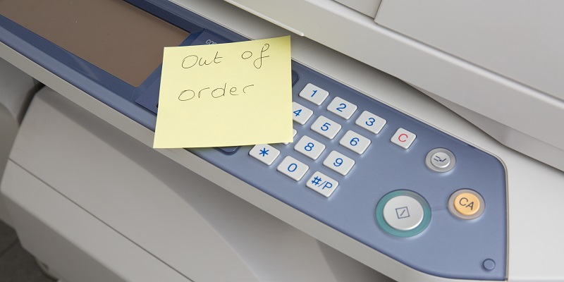Rent Copy Machine A copy machine with a note on it stating that the machine is out of order