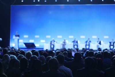 Presenters on stage in front of a crowd