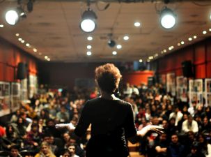 An individual on stage giving a presentation