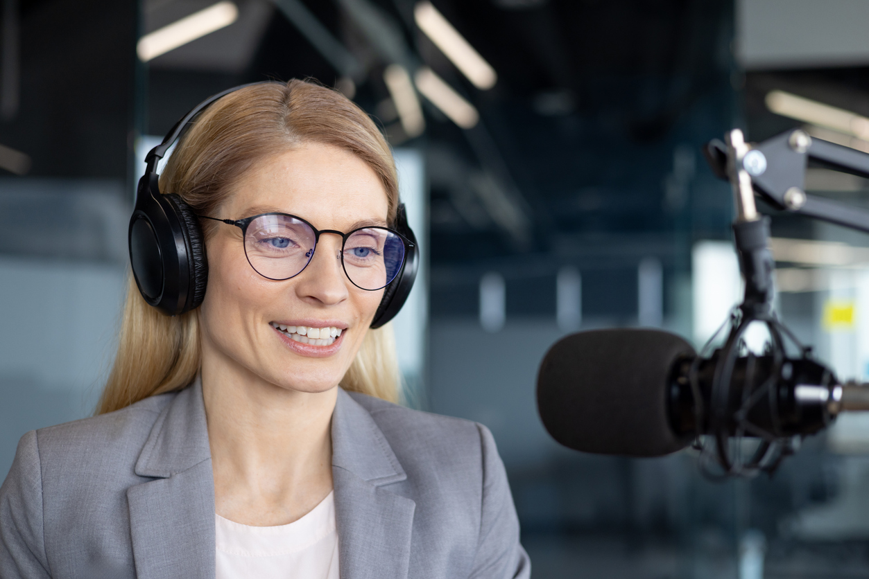 Human interpreter listening through headphones and translating live event content