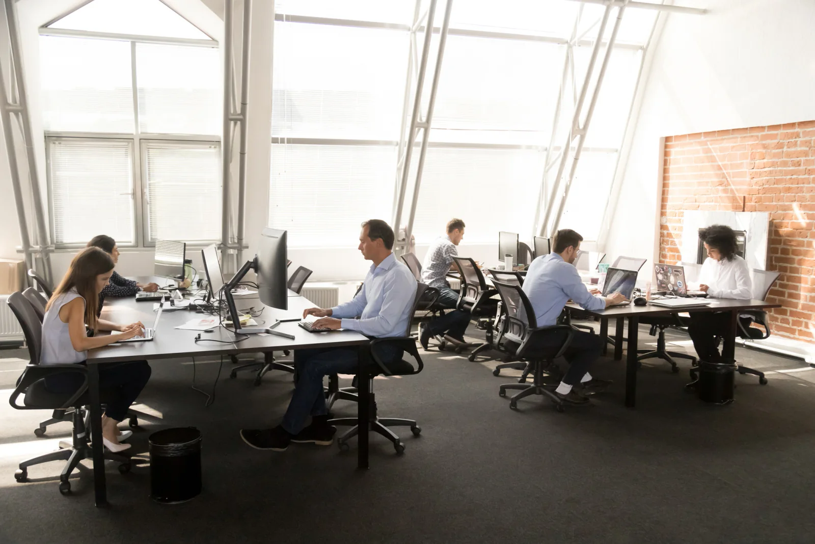 Temporary office space with rows of desks, computers, and monitors for displaced employees during disaster recovery