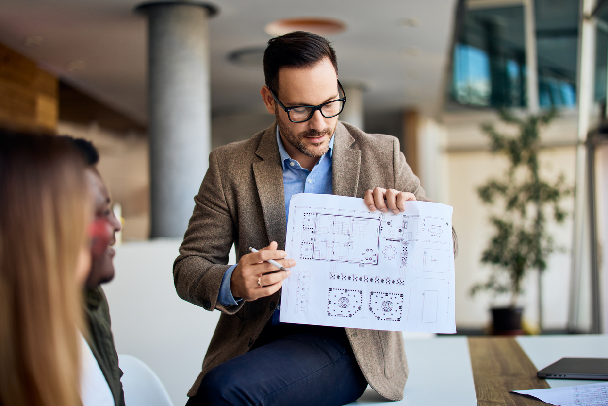 Event planner reviewing a conference floor plan for multilingual interpretation services
