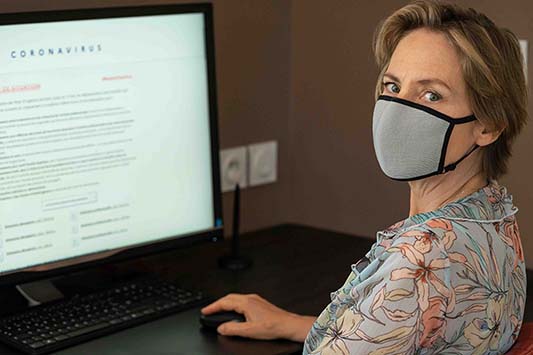 A mask-wearing woman on a website displaying information about the coronavirus