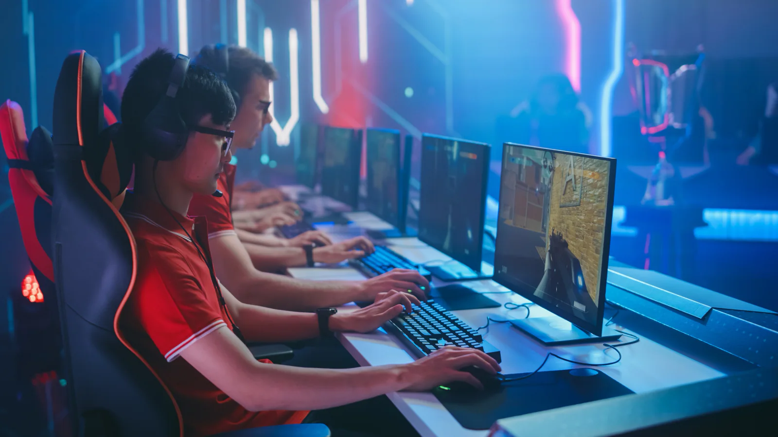 Public gaming activation with branded esports stations, large screens, and attendees participating in live gameplay