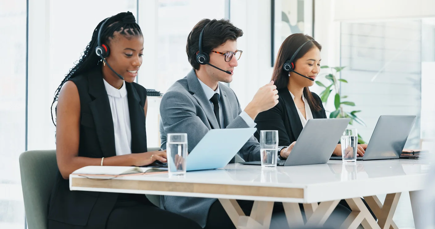 Short-term business team using laptops and headsets in a temporary office with cloud calling and collaboration tools