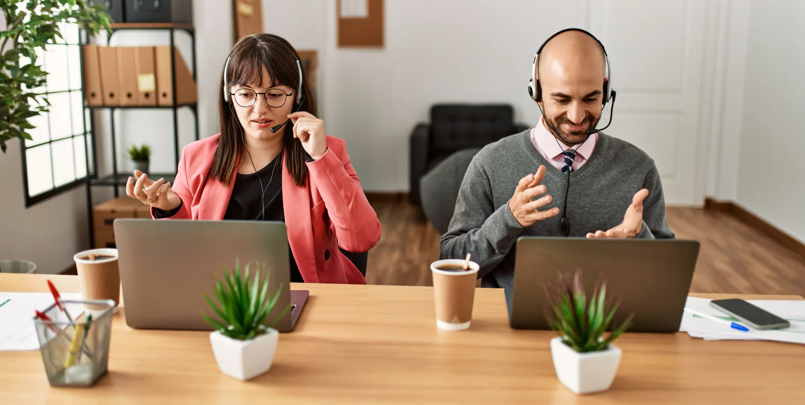 Temporary office team using laptops, headsets, and collaboration software in a pop-up workspace prepared for cloud communications
