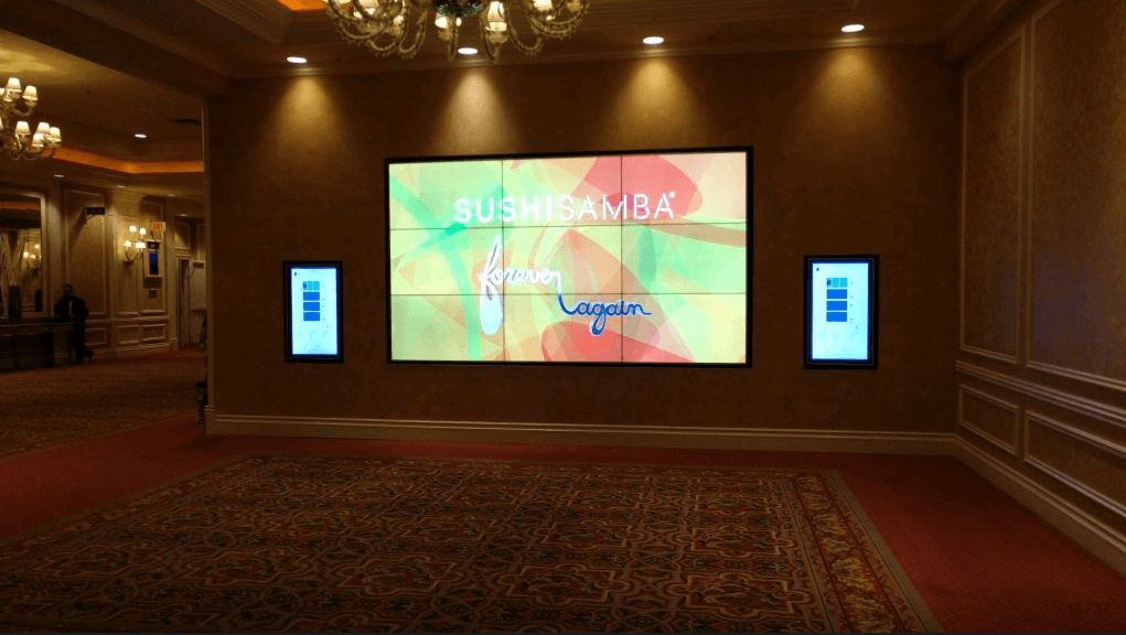 A mounted 3x3 video wall disaplying a company's logo