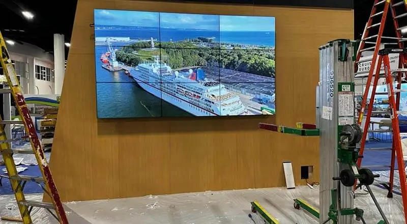 A 3x3 video wall installation during the final phase of testing. All 9 screens are combining to display an image of a cruise ship