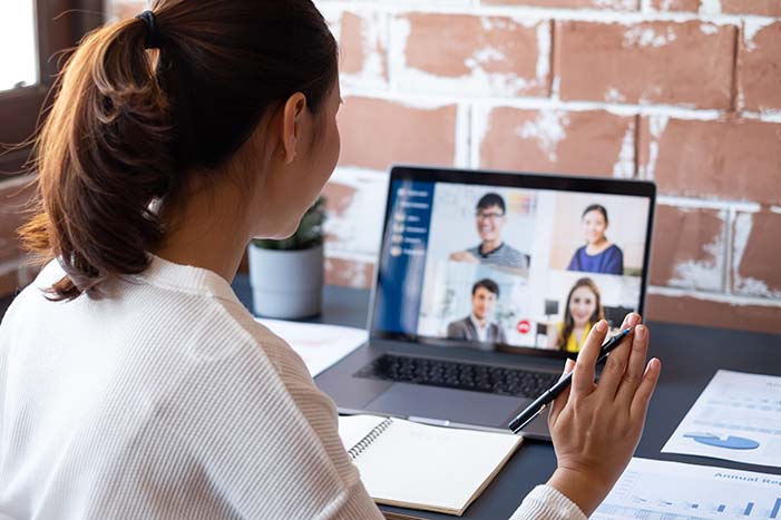 A woman in a virtual meeting on a laptop